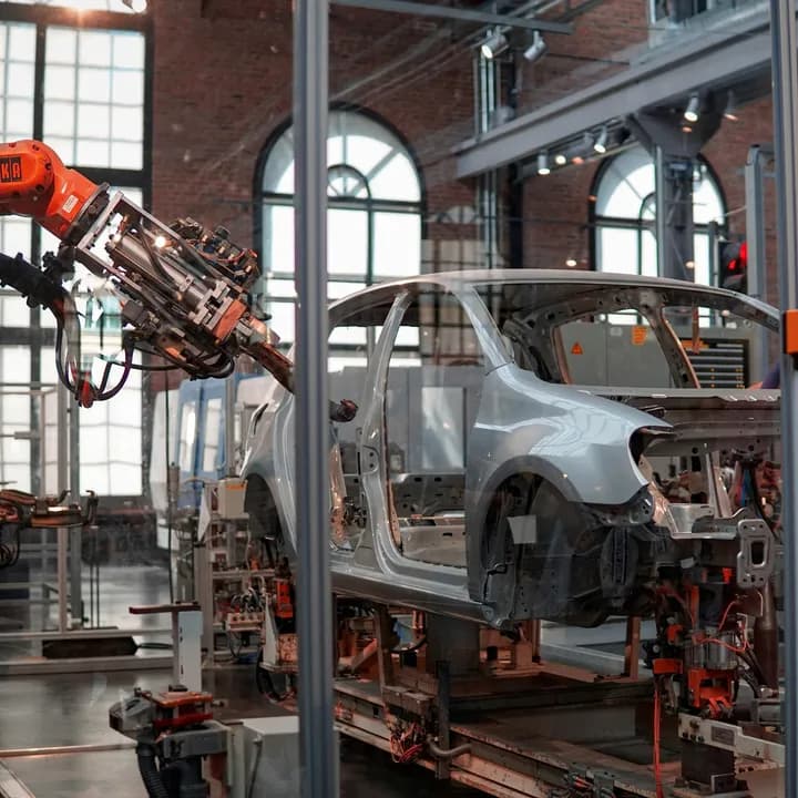 A robot arm working on a car body at an assembly line.